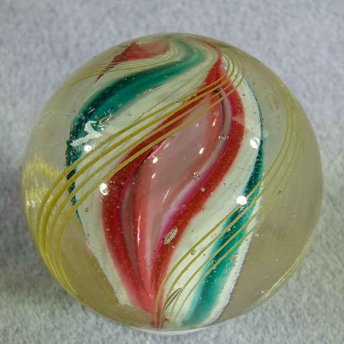 SWIRL, Solid Core. 25/32". Mint(-) (9.2).: SWIRL, Solid Core. Interesting Solid Core Swirl. Core is white with two turquoise bands and two pink bands. The pink bands each have an elongated air bubble in them which is part of the design.