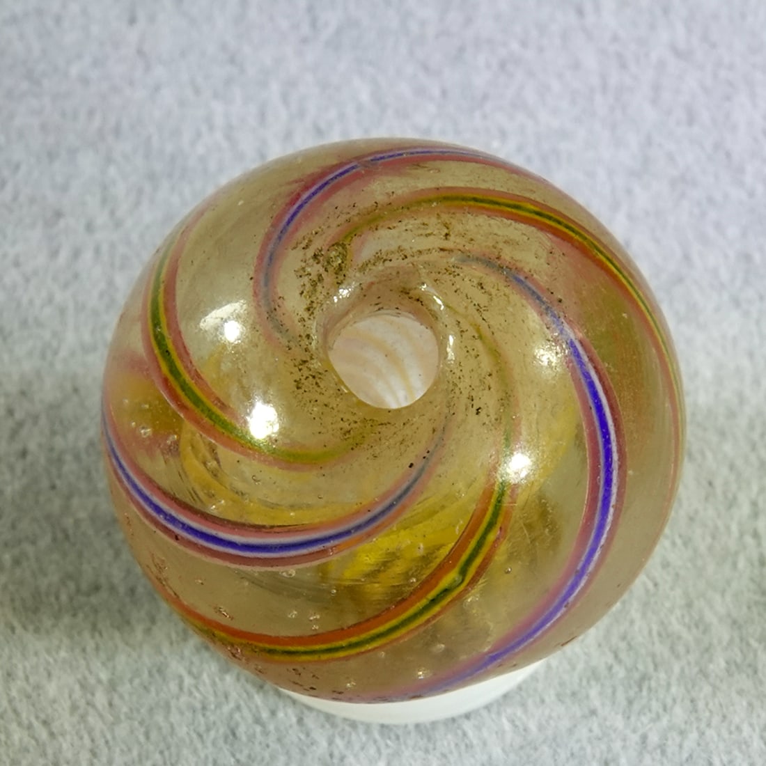 SWIRL, Trade Bead. 11/16". Near Mint(+) (8.7).: SWIRL, Trade Bead. Extremely rare Trade Bead. Handmade Latticinio Core Swirl. Yellow core. Has a hole melted through it. These German beads were used as trade good, predominately in Africa in the 2nd