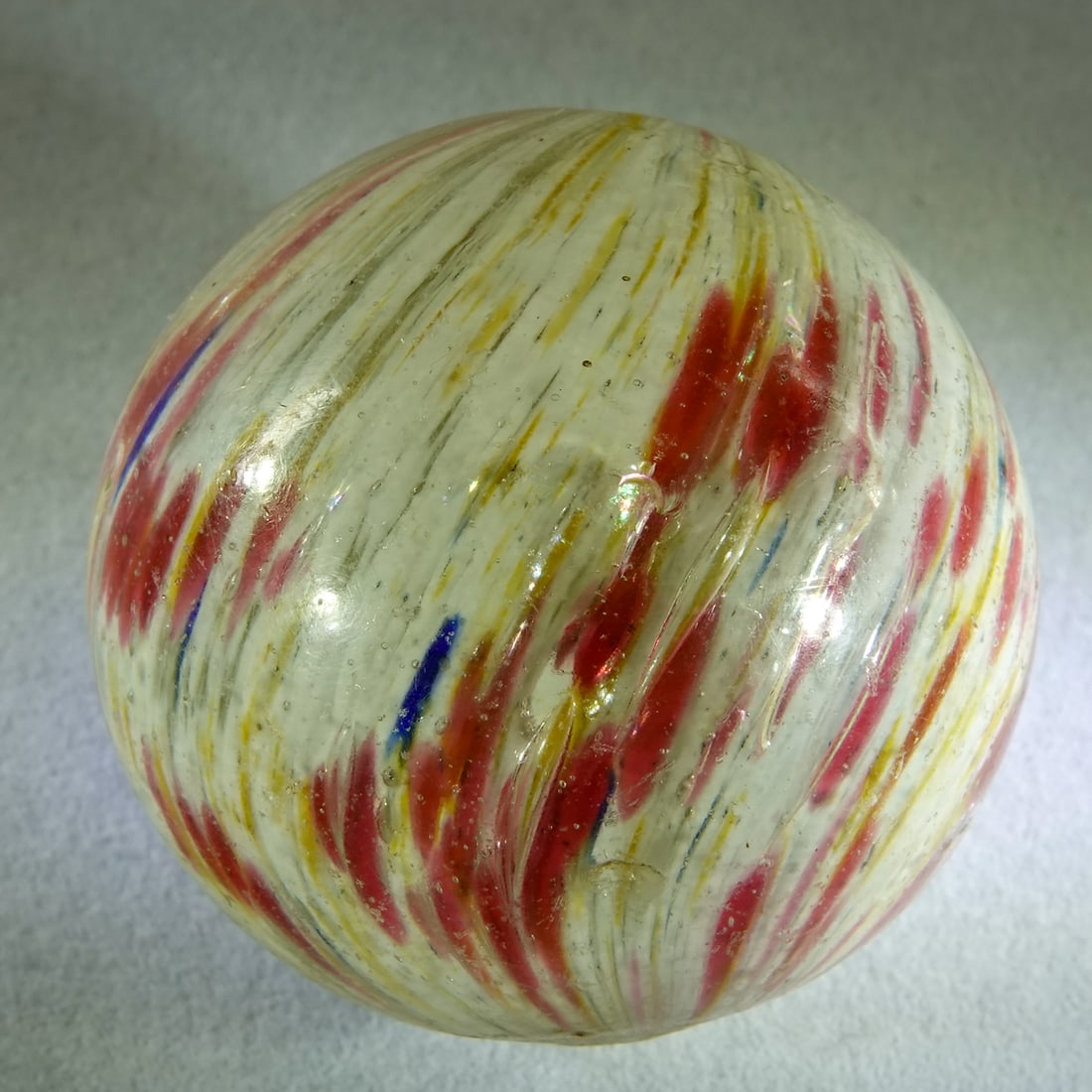 END OF DAY, Onionskin. 1-3/4". Near Mint (8.6).: END OF DAY, Onionskin. White core with pink and yellow skin and a little blue. There are elongated air bubbles on the core (under the clear surface layer) that give the appearance of mica.