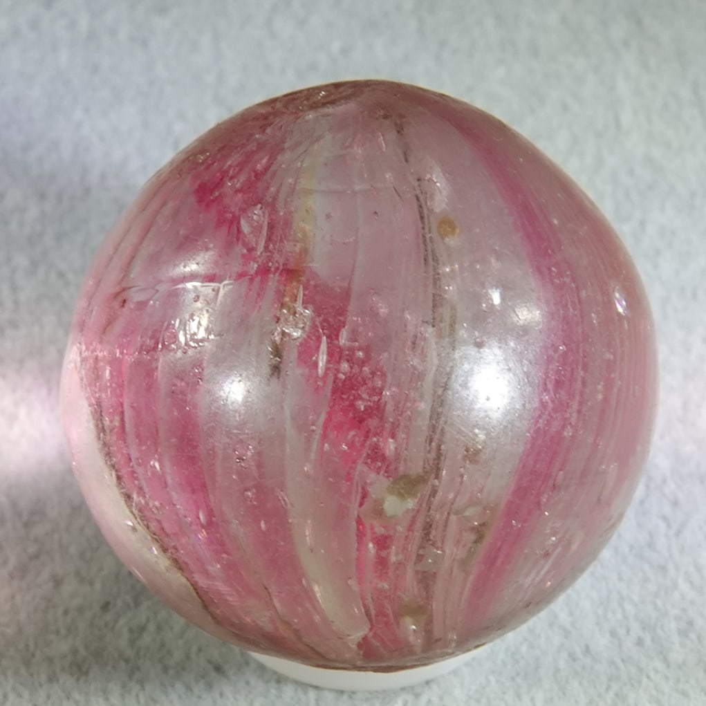 OTHER HANDMADE, Mist. 25/32". Near Mint(+) (8.7).: OTHER HANDMADE, Mist. Transparent clear base. Subsurface layer is stretched transparent pink bands with some mica. Tiny chip, tiny subsurface moon, a tiny it of pocket wear. Germany, circa 1860-1920.