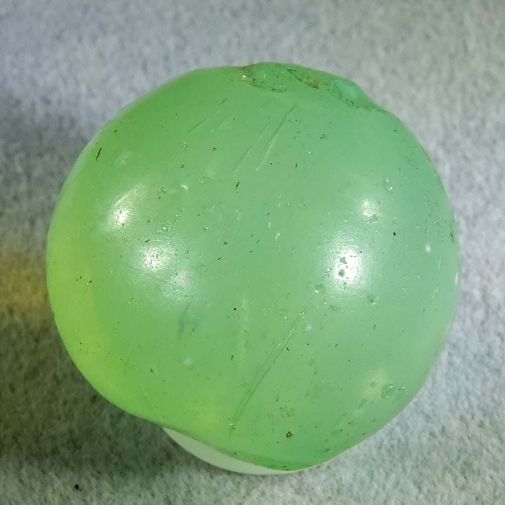 OTHER HANDMADE, Opaque. 3/4". Near Mint(+) (8.7).: OTHER HANDMADE, Opaque. Two-pontil marble. Melon Ball. Semi-translucent Sea Foam Green with unmelted sand in the marble. A tiny chip, one very small manufacturing flake caused by a sand seed, some