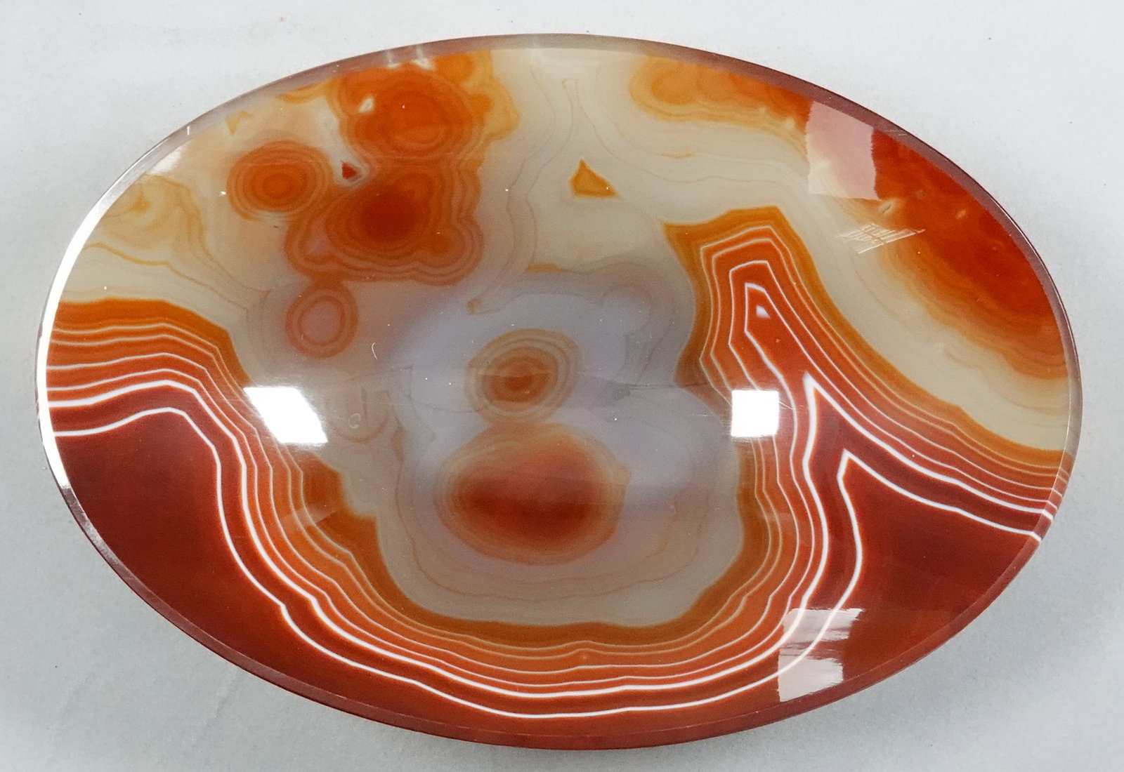 MISCELLANEOUS, Agate. Bowl.: MISCELLANEOUS, Agate. A handcut and hand ground antique agate bowl. Banded Agate from Idar-Oberstein. Carved and ground into an oval bowl with a foot. Nice faceting on the outside of the bowl. 6-5/8"