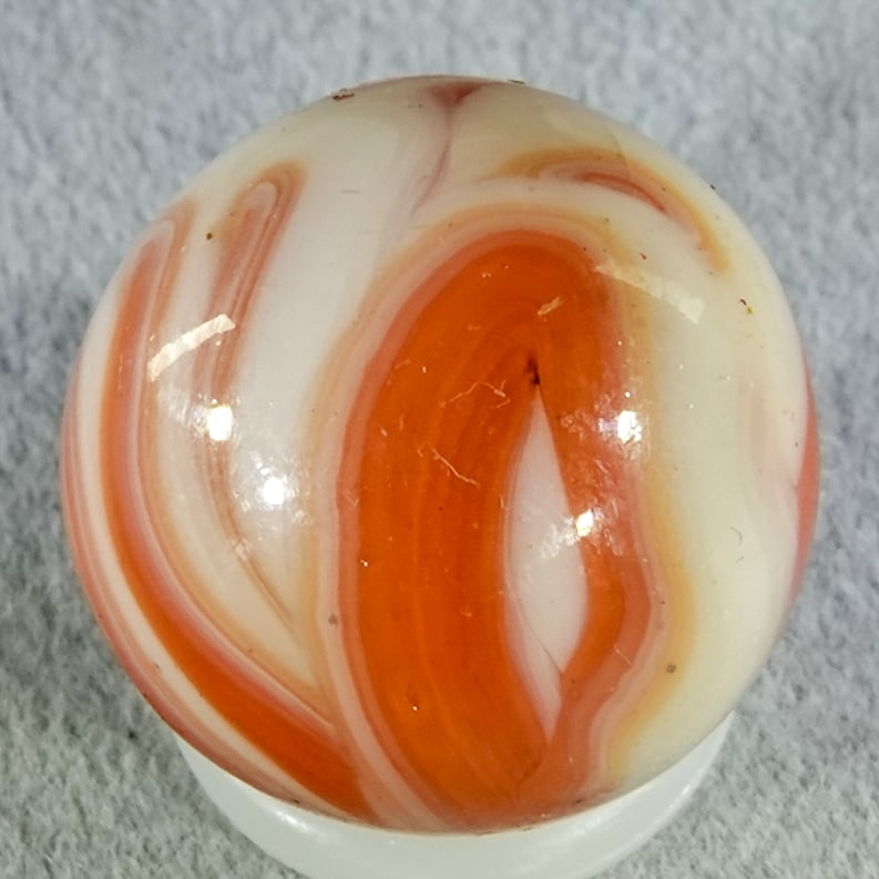 CHRISTENSEN AGATE COMPANY, Flame Swirl. 19/32". Mint (9.9).: CHRISTENSEN AGATE COMPANY, Flame Swirl. Salmon swirls (two-tone) in white. Some flame tips. Cambridge OH, circa 1925-1930. 19/32". Mint (9.9).