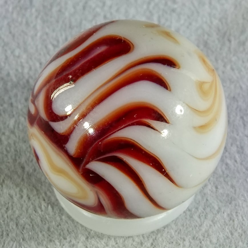 CHRISTENSEN AGATE COMPANY, Flame Swirl. 19/32". Mint (9.9).: CHRISTENSEN AGATE COMPANY, Flame Swirl. Transparent red and very light red swirls in white. Some flame tips. Cambridge OH, circa 1925-1930. 19/32". Mint (9.9).