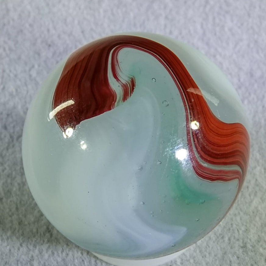 AKRO AGATE COMPANY, Silver Oxblood. 3/4". Mint (9.9).: AKRO AGATE COMPANY, Silver Oxblood. Nice oxblood swirled on a translucent milky white base with some opaque white. Shooter. Clarksburg WV, circa 1925-1935. 3/4". Mint (9.9).