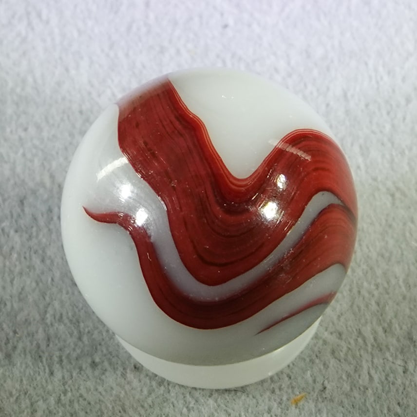 AKRO AGATE COMPANY, Swirl Oxblood. 19/32". Mint (9.9).: AKRO AGATE COMPANY, Swirl Oxblood. Opaque white base with oxblood swirls. Clarksburg WV, circa 1925-1935. ex-collection: Ralph Stagg 19/32". Mint (9.9).