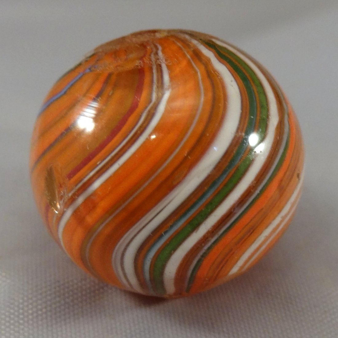 Marbles: Lot 49. SWIRL, Joseph Coat. Mint(-) (9.1).: Lot 49. SWIRL, Joseph Coat. Subsurface layer predominately orange with some other colors, and aventurine green. Three small melt spots on the surface. Germany, circa 1860-1920. 3/4". Mint(-) (9.1).