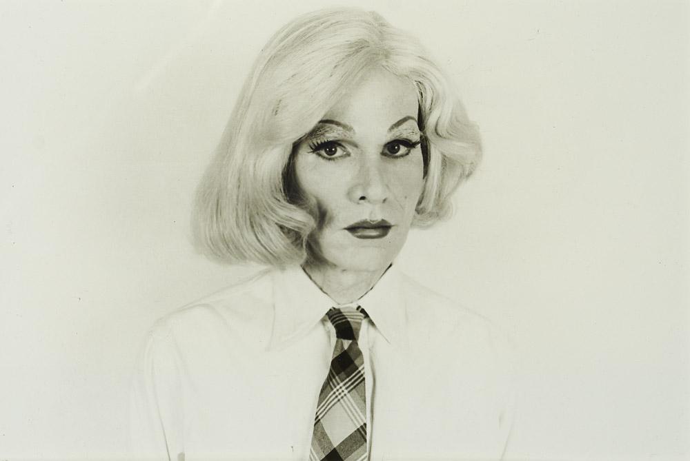 Makos, Christoph Andy Warhol mit blonder: Pop Art - Andy Warhol Makos, Christoph Andy Warhol mit blonder Kurzhaarperücke und Schlips. 1981. Silber gelatin print auf Photopapier. 47,9 x 34,3 cm (Sichtmaß). Verso mit Sichtfenster mit 