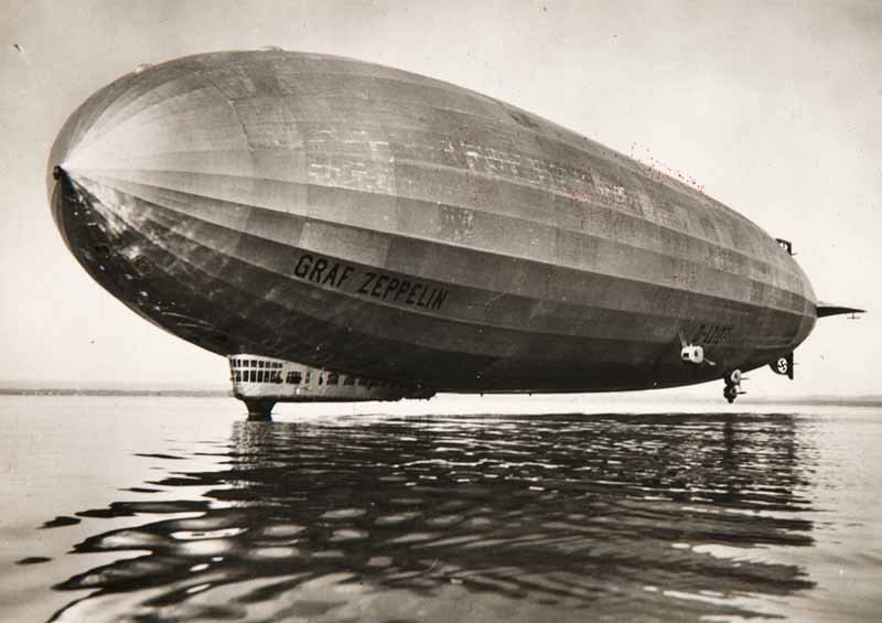 12 Photographien 6 1/2 x 9 cm "Graf Zeppelin". Ca. 19: 12 Photographien 6 1/2 x 9 cm "Graf Zeppelin". Ca. 1936. 12 OPhotographien, Vintages, Silbergelatine Abzüge lose in OPp.-Mappe. Verso mit aufgedruckter Beschreibung sowie mit Stempel "Zur Erinnerung 