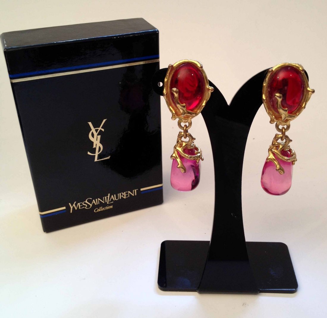 YVES SAINT LAURENT Paire de clips d'oreilles feuillage : YVES SAINT LAURENT Paire de clips d'oreilles feuillage en métal doré perles de verre rouge et fushia- hauteur : 6,5cm Earclips with red and pink glass - height : 2,5 in. ( good condition)