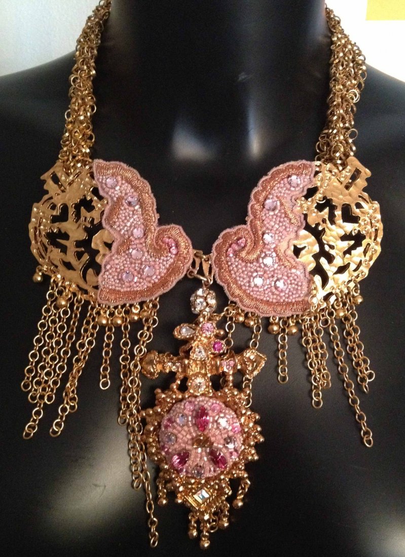 CHRISTIAN LACROIX Collier multi chaînes retenant un lar: CHRISTIAN LACROIX Collier multi chaînes retenant un large médaillon à pampilles agrémenté de broderies perlées roses, longueur: 48 cm - gold tone multi chains necklace decorated with pink lace a