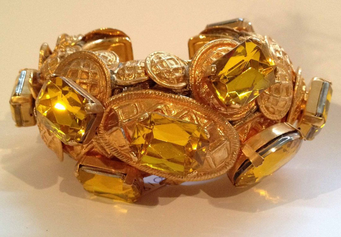 ROCHAS Bracelet manchette sculpture recouvert de bouton: ROCHAS Bracelet manchette sculpture recouvert de boutons stylisés et de pierres facettées en résine jaune - Largeur : 5cm Spectacular cuff bracelet covered with yellow resin stones and buttons - Wi