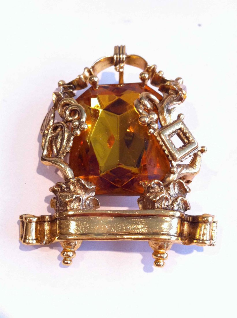 KARL LAGERFELD par GOOSSENS Broche pendentif en métal d: KARL LAGERFELD par GOOSSENS Broche pendentif en métal doré ajouré ornée d'un important strass ambré - Hauteur : 7,5 cm - Height : 2,9 in. (très bon état/very good condition)