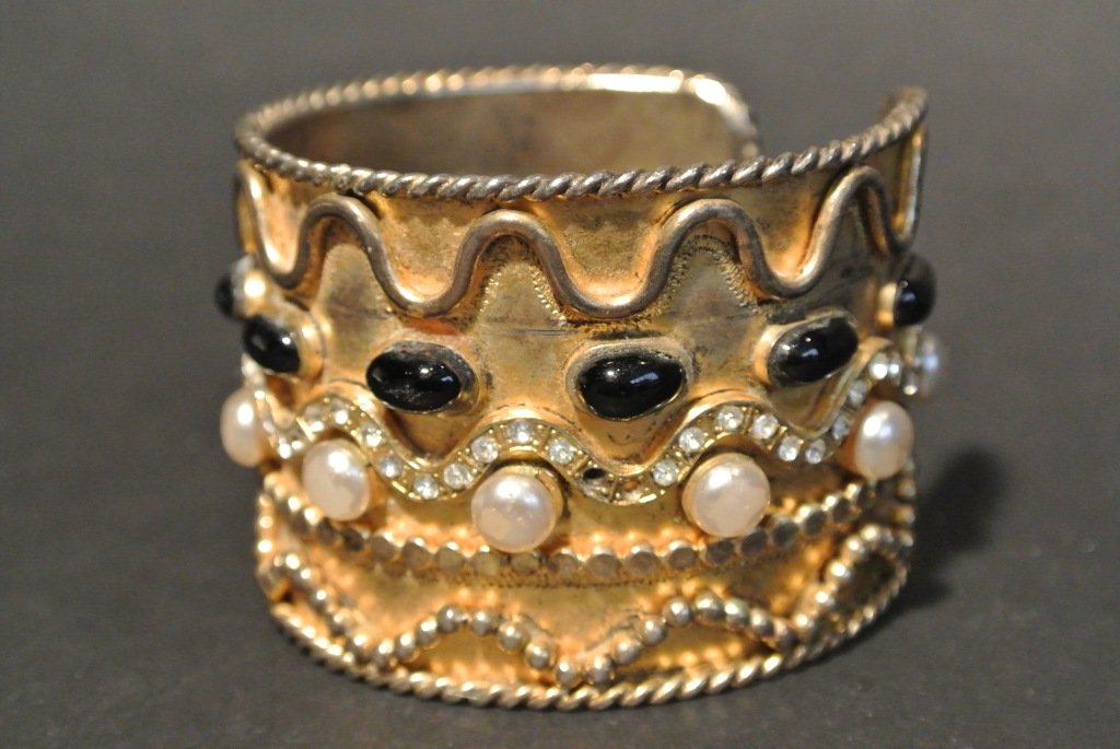 YVES SAINT LAURENT Rive Gauche Bracelet manchette Proto: YVES SAINT LAURENT Rive Gauche Bracelet manchette Prototype en métal doré composé de motifs de vagues, orné de verre noir, perles nacrées et strass - Hauteur: 4,5cm (usures et manques) Gold tone 