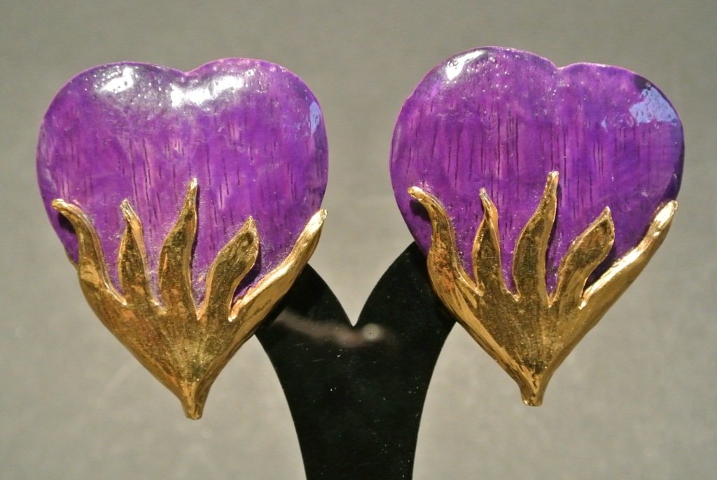 YVES SAINT LAURENT Paire de clips "Coeur enflammé" en m: YVES SAINT LAURENT Paire de clips "Coeur enflammé" en métal doré et bois teinté violet - Hauteur : 6 cm - Width : 2,3 in. YVES SAINT LAURENT Wood and gold tone heart shape pair of earrings - Width