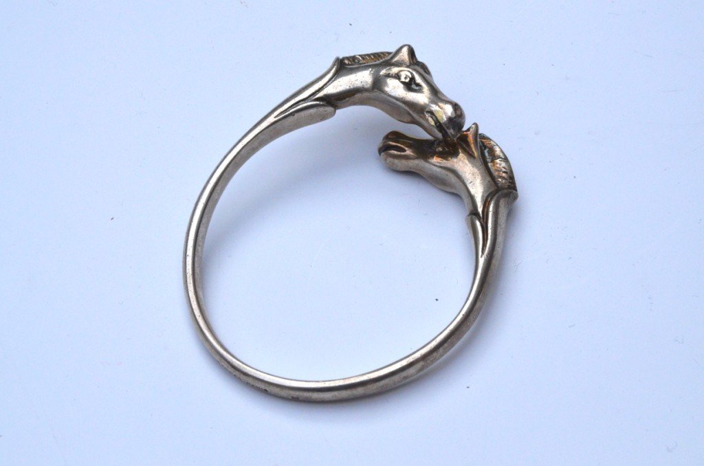 HERMES Paris Bracelet rigide en métal agenté figurant: HERMES Paris Bracelet rigide en métal agenté figurant deux têtes de cheval - Diamètre : 7 cm
