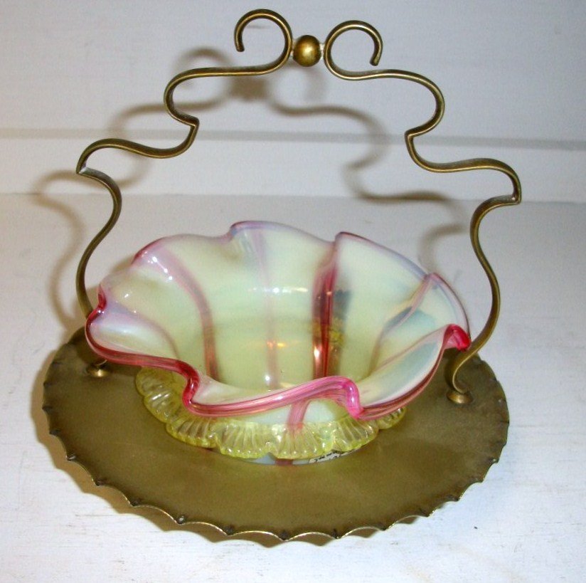 Stevens and Williams Art Glass Basket: 6 1/2" tall 6 1/2" dia metal basket with glass insert. Candy ribbon cranberry and yellow with applied glass surround. Polished pontil unsigned attributed to Stevens and Williams