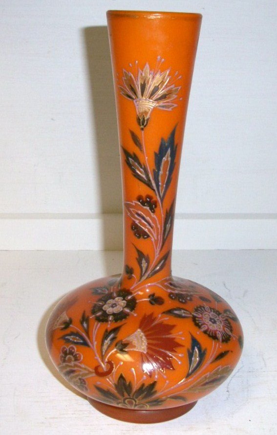 English Enamelled Vase: 10" tall Vibrant pumkin orange color with heavily enamelled florals. The pulled and twisted pontil is indicative of Thomas Webb, the Pumkin color is that of Stevens and Williams. Unable to attribute t