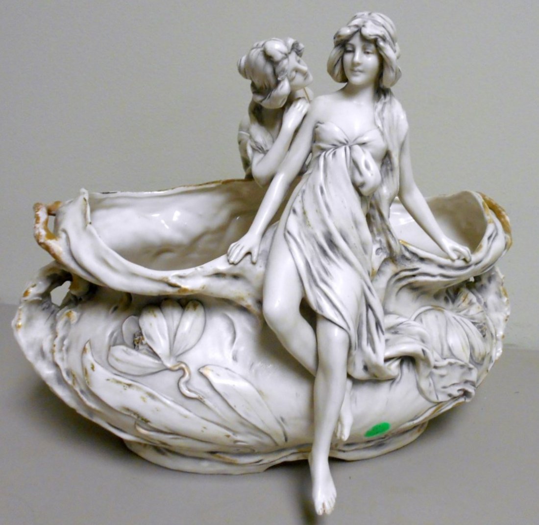 Large Royal Dux Figural Bowl: Stunning 15" long and 12" tall two figure Royal Dux Basket bowl. Two art Nouveau women whispering secrets on afloral bowl. Satin mat finish with heavy gold accents. Signed with large pink triangle mar