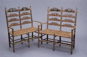 PAIR OF CONTINENTAL (POLYCHROME PAINTED SETTEES. 1: PAIR OF CONTINENTAL (POLYCHROME PAINTED SETTEES. 19th Century. With double chair-backs above out-curved drums, rush seats,, turned legs, ball feet and stretchers. The whole with curly-cue decoration a