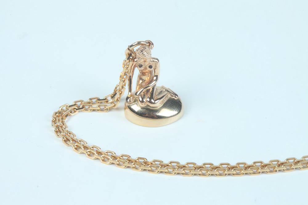 DANISH 14K YELLOW GOLD FIGURAL PENDANT ON 14K YELLOW GOLD CHAIN. - Wt.: 10 dwt.: DANISH 14K YELLOW GOLD FIGURAL PENDANT ON 14K YELLOW GOLD CHAIN. Pendant sculpted as female nude seated on mount, L: 3/4"; oblong link chain, L: 27". - Wt.: 10 dwt.