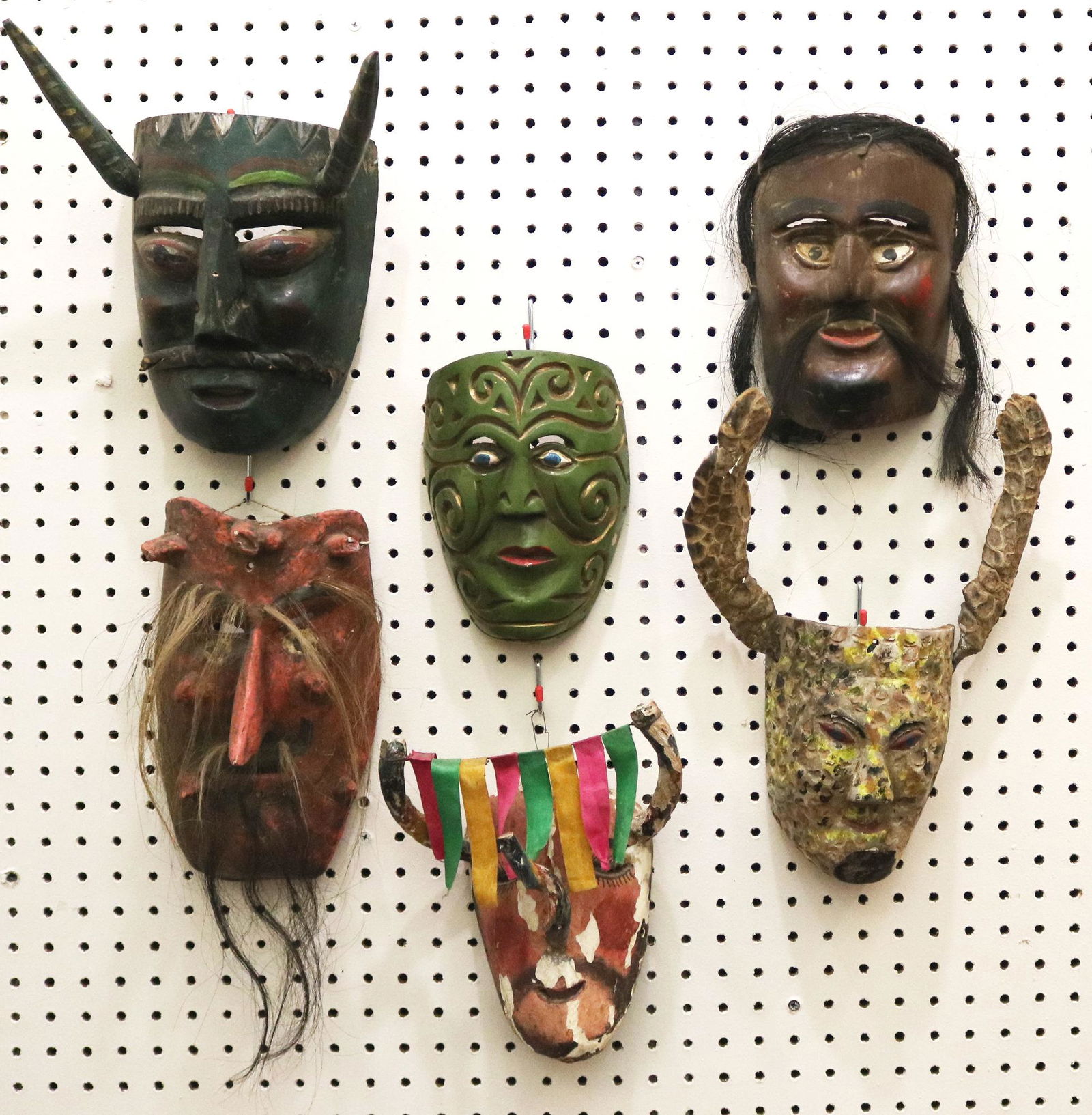 SIX GUATEMALAN FESTIVAL CARVED MASKS, Mid-to-late 20th Century. - height: 9 inches (green mask with: SIX GUATEMALAN FESTIVAL CARVED MASKS, Mid-to-late 20th Century. Hand carved and decorated wooden Guatemalan festival masks which are used for traditional dances during festivals. There are signs of ha