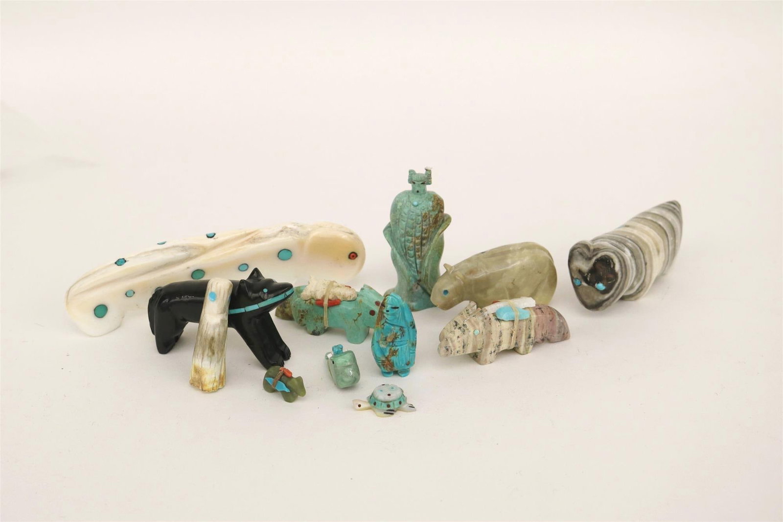 12 NATIVE AMERICAN CARVINGS,: 12 NATIVE AMERICAN CARVINGS. Selection of 12 Native American small-and-medium-sized carvings. Most carvings depict animals; materials used include jet, shell, malachite, coral, travertine, glass, cla