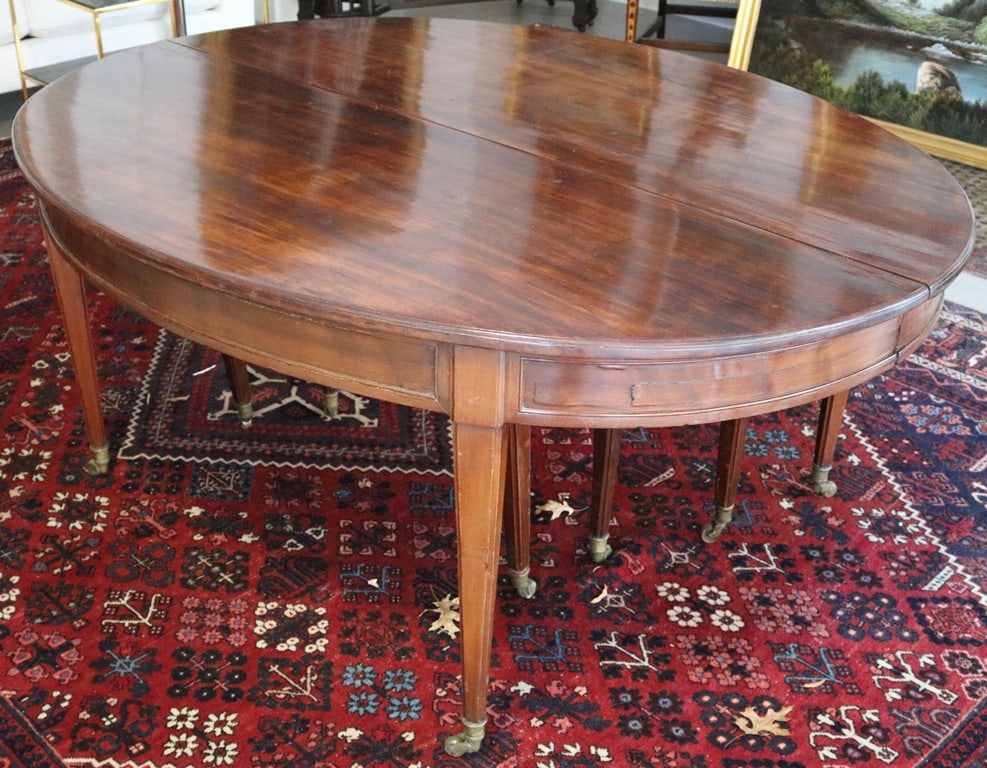 19TH CENTURY MAHOGANY BANQUET TABLE, 1850 -1870. - Fully extended: 176 in. x 68 in. x 28 1/2 in.;: 19TH CENTURY MAHOGANY BANQUET TABLE, 1850 -1870. Oval ends, tapering square legs raised on casters. Four original leaves, and one later made - Fully extended: 176 in. x 68 in. x 28 1/2 in.; top, 52 in