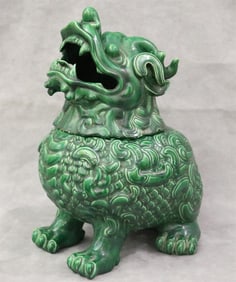 20TH CENTURY CHINESE GREEN-GLAZED LIFT-COVER VESSEL MODELED AS FU DOG. - H: 15".