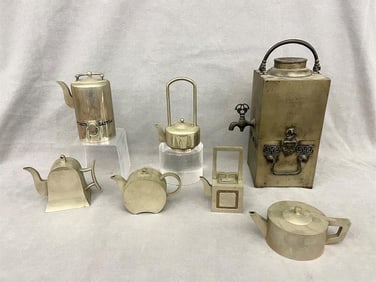 SIX CHINESE-INSPIRED ART DECO METAL MINIATURE TEAPOTS AND A SIMILAR SQUARE-SIDED DRINKS DISPENSER .