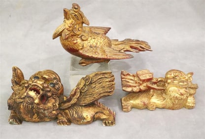 THREE CHINESE CARVED AND GILT WOOD FIGURES: BIRD OF PARADISE AND TWO FOO DOGS.