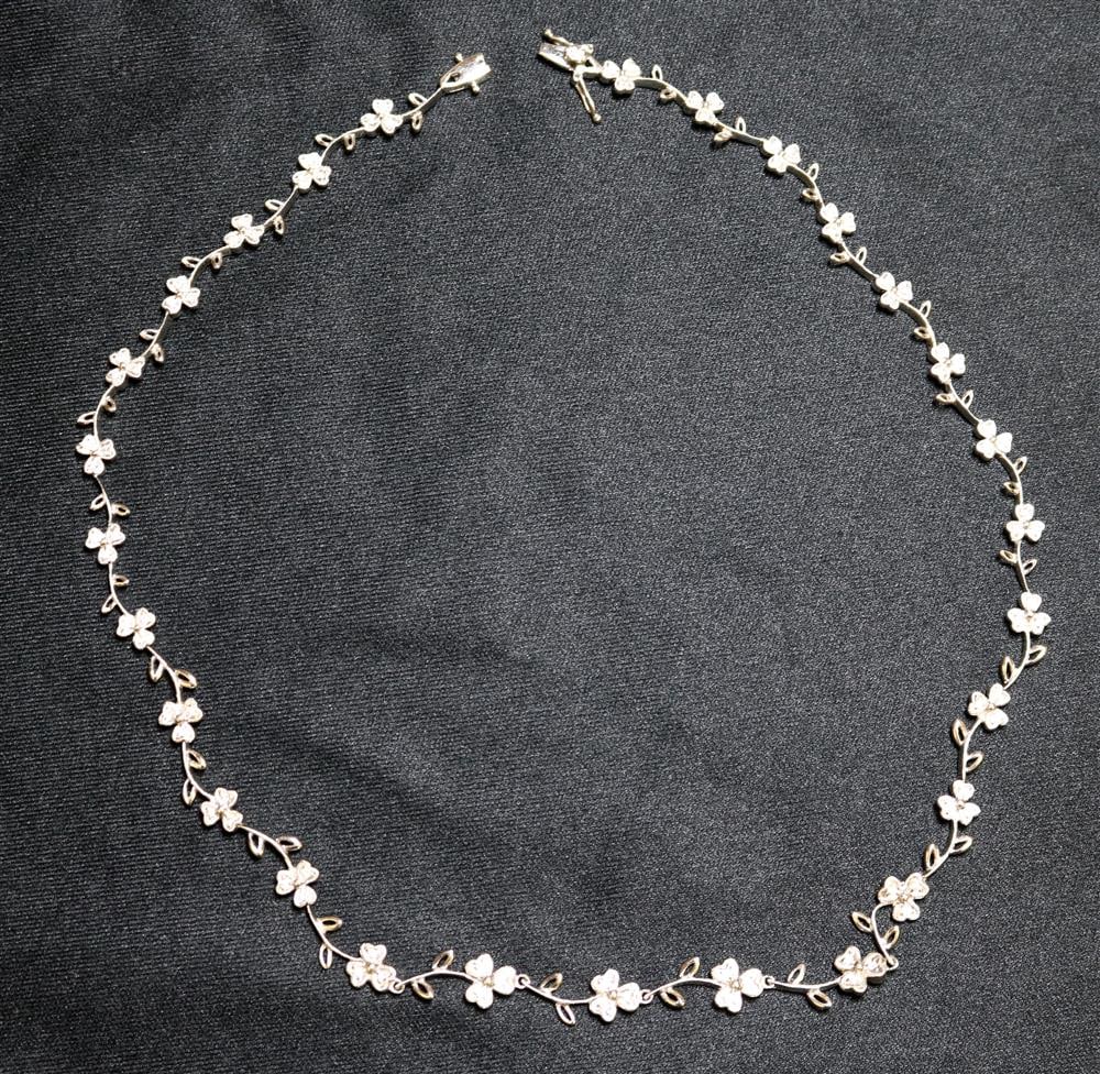 14K (585) WHITE GOLD AND DIAMOND CLOVER DESIGN FLEXIBLE-LINK CHOKER. - L: 15 1/ in. Gross wt. 10: 14K (585) WHITE GOLD AND DIAMOND CLOVER DESIGN FLEXIBLE-LINK CHOKER. Fashioned as delicate trailing vine spaced by 28 three-leaf clovers each set with three round diamonds alternating with pairs of op