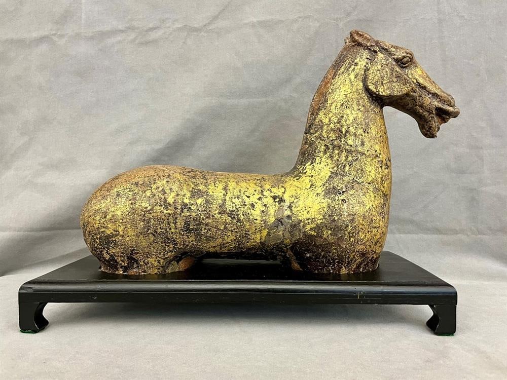 CHINESE STYLE GILT METAL FIGURE OF RECLINING HORSE AFTER THE ANTIQUITY. - H: 16"; L: 20 3/8"(base).: CHINESE STYLE GILT METAL FIGURE OF RECLINING HORSE AFTER THE ANTIQUITY. On fitted ebonized wooden plinth base. - H: 16"; L: 20 3/8"(base).