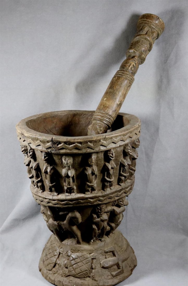 AFRICAN WOODEN MORTAR AND PESTLE, 20th century. - Height (mortar): 13 inches; lenght (pestle): 17.5: AFRICAN WOODEN MORTAR AND PESTLE, 20th century. Patinated decorated hand-carved wooden mortar and pestle. - Height (mortar): 13 inches; lenght (pestle): 17.5 inches.