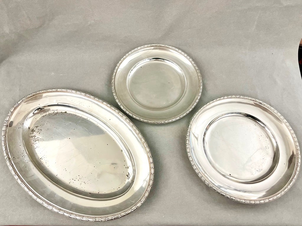SET OF THREE CONTINENTAL HEAVY SILVER-PLATED SERVING PLATTERS,: SET OF THREE CONTINENTAL HEAVY SILVER-PLATED SERVING PLATTERS. Each with neoclassical leaf and berry relief border decoration. One, oval, L: 19"; two, graduated circular, 12 3/4" and 11 1/2".
