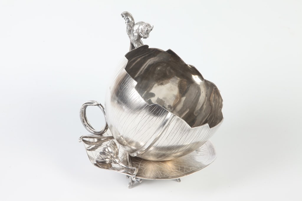 LATE 19TH CENTURY VICTORIAN MERIDAN CO. FRUIT/NUT BOWL. Naturalistically cast as half-nut shell with: LATE 19TH CENTURY VICTORIAN MERIDAN CO. FRUIT/NUT BOWL. Naturalistically cast as half-nut shell with linear markings, resting on lily pad with two stemmed blossoms, and surmounted by nibbling squirrel
