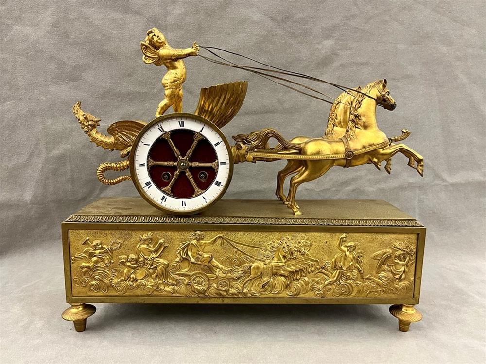 FRENCH NEOCLASSICAL GILT-BRONZE MANTEL CLOCK, By Leroy a Paris, 19th century. - H: 16 in.: FRENCH NEOCLASSICAL GILT-BRONZE MANTEL CLOCK, By Leroy a Paris, 19th century. Sculpted figure of cherub in chariot pulled by two horses, with dragon motif, surmounts frieze panel with mythological cha