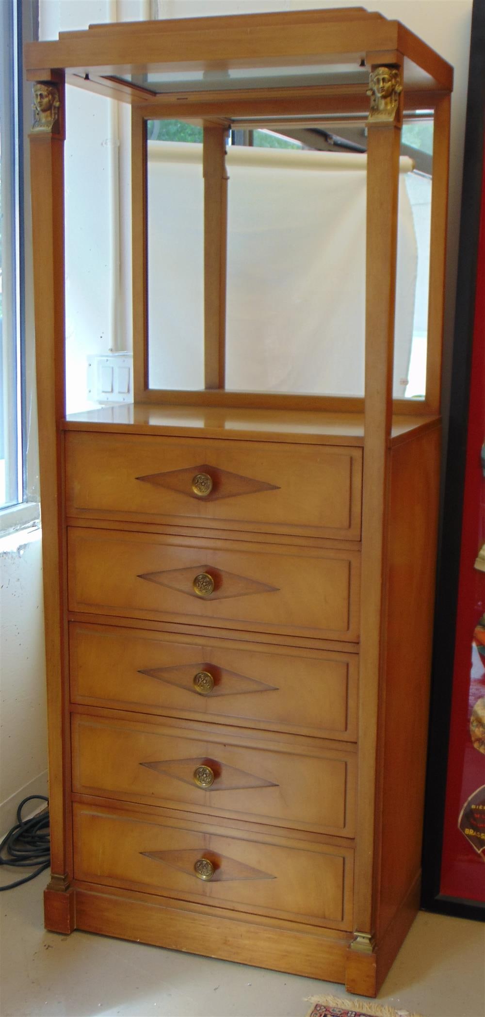 GROSFELD HOUSE BIEDERMEIER STYLE WALNUT FIVE-DRAWER DISPLAY VITRINE. 1960S. - H: 76"; W: 31"; D:: GROSFELD HOUSE BIEDERMEIER STYLE WALNUT FIVE-DRAWER DISPLAY VITRINE. 1960S. Labeled. Upper portion has stepped columns with cast brass head of classical maidens; mirror back; bank of five drawers with