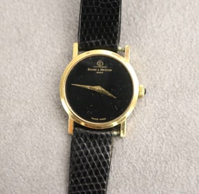 LADY'S BAUME & MERCIER 18K YELLOW GOLD WRISTWATCH WITH BLACK LEATHER STRAP.