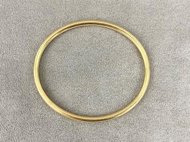 TIFFANY & CO. 14K (585) BRIGHT-POLISHED YELLOW GOLD OVAL, TUBULAR, SLIP-ON BANGLE BRACELET.