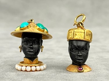TWO PENDANT/CHARMS CONSTRUCTED AS 18K YELLOW GOLD MOUNTED CARVED EBONY BUST FIGURES OF AFRICAN