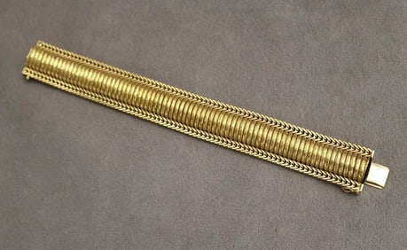 18K (750) TEXTURED AND RIBBED YELLOW GOLD FLEXIBLE DOMED STRAP BRACELET.