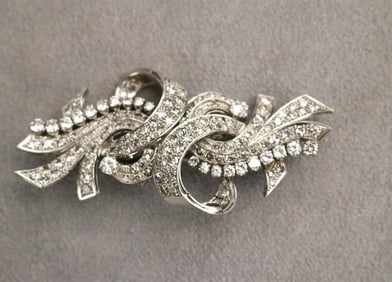 1940S PLATINUM AND DIAMOND SCROLL-AND-RIBBON DESIGN PIN CONVERTIBLE TO PAIR CLIPS.