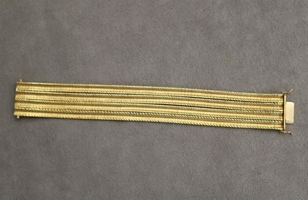 18K (750) TEXTURED AND BRIGHT-POLISHED YELLOW GOLD FLEXIBLE STRAP BRACELET.