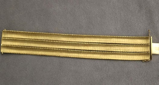 18K (750) TEXTURED AND BRIGHT-POLISHED YELLOW GOLD FLEXIBLE STRAP BRACELET.