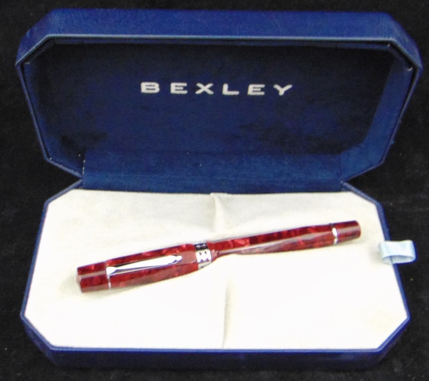 TWO BEXLEY ROLLER BALL PENS.: TWO BEXLEY ROLLER BALL PENS. One, marbled blue; one, marbled red. Each in shaped hinged-lid box marked with logo.