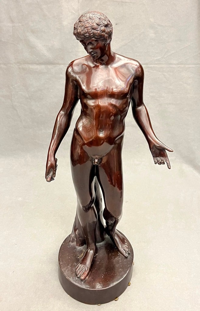 BRONZE FIGURE CAST AS ANTINOUS, AFTER THE ANTIQUE, - Height: 24 1/2".: BRONZE FIGURE CAST AS ANTINOUS, AFTER THE ANTIQUE. Youth holding scroll stands before tree trunk. - Height: 24 1/2".