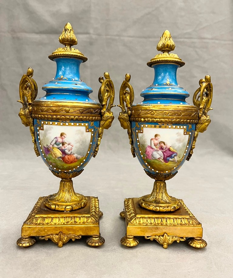 PAIR 19TH CENTURY SEVRES CABINET GILT-METAL MOUNTED POLYCHROMED CELESTE BLUE PORCELAIN CABINET URNS.: PAIR 19TH CENTURY SEVRES CABINET GILT-METAL MOUNTED POLYCHROMED CELESTE BLUE PORCELAIN CABINET URNS. Reserves depicting 18th century couples country in landscape, reverse to polychromed floral sprays;