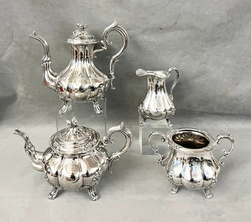 FRENCH SILVER FOUR-PIECE COFFEE/TEA SERVICE, early 20th century, made Paris by Alphonse Debain. -: FRENCH SILVER FOUR-PIECE COFFEE/TEA SERVICE, early 20th century, made Paris by Alphonse Debain. Marked "Debain". Lobed pyriform vessels with chased cartouche-form reserves; four scroll feet; covers ha