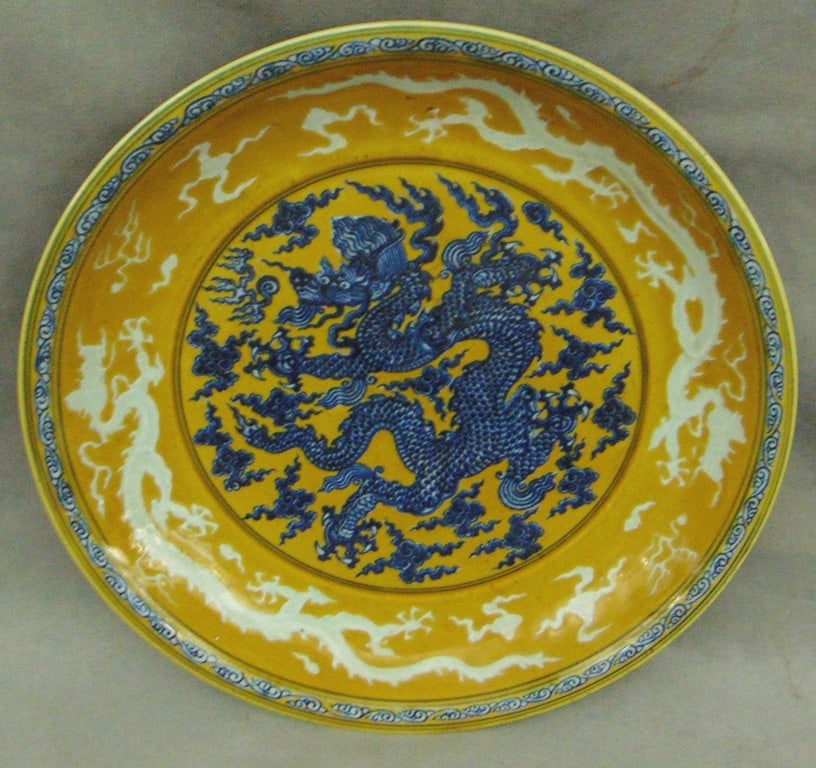 CHINESE BLUE AND WHITE DECORATED PORCELAIN CHARGER, - D: 15 3/4 in.: CHINESE BLUE AND WHITE DECORATED PORCELAIN CHARGER. Writhing dragon decoration on mustard and yellow ground with additional dragons in white - D: 15 3/4 in.